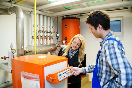 Das Foto zeigt einen Heizungstechniker im Heizraum