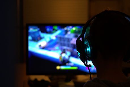 Mann vor Bildschirm mit Computerspiel