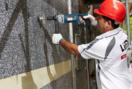 Das Foto zeigt einen Handwerker bei Dämmarbeiten