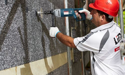 Das Foto zeigt einen Handwerker bei Dämmarbeiten
