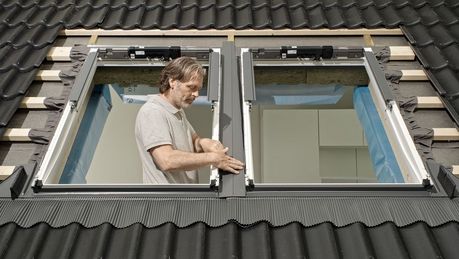 © velux Das Foto zeigt einen Handwerker beim Einbau eines Dachfensters.