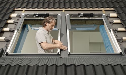 © velux Das Foto zeigt einen Handwerker beim Einbau eines Dachfensters