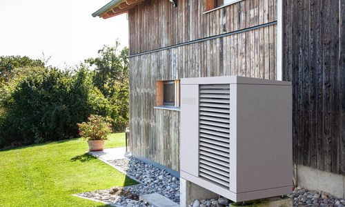 Das Foto zeigt ein Haus mit einer Wärmepumpe
