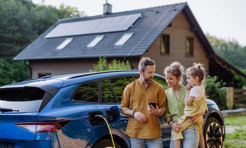 Das Foto zeigt eine Familie mit E-Auto beim Laden