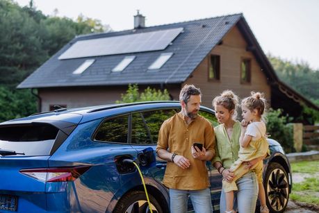 Das Foto zeigt eine Familie mit E-Auto beim Laden