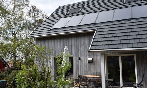 Holzhaus mit Solaranlage auf dem Dach