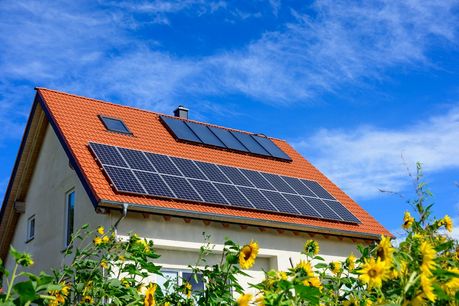 Das Foto zeigt ein Hausdach mit Photovoltaik- und Solartermieanlage