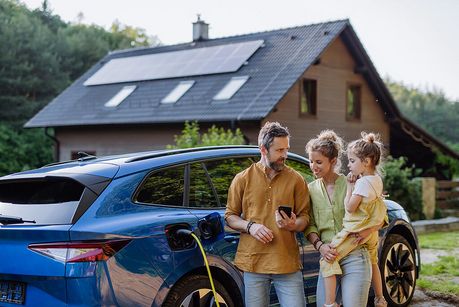 Familie vor Elektroauto mit Solarstromanlage