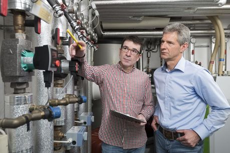 Energieberater erklährt Hausbesitzer seine Heizungstechnik