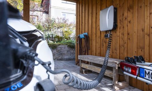 Das Bild zeigt ein E-Auto, das an der Wallbox hängt
