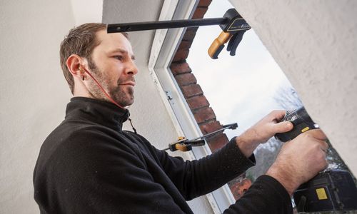 EiN Handwerker montiert ein Fenster