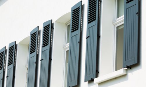 Canva Das Foto zeigt eine Fassade mit Fensterläden