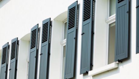 Canva Das Foto zeigt eine Fassade mit Fensterläden