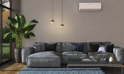 Das Bild zeigt ein Wohnzimmer mit einem Split-Klima-Gerät an der Wand
