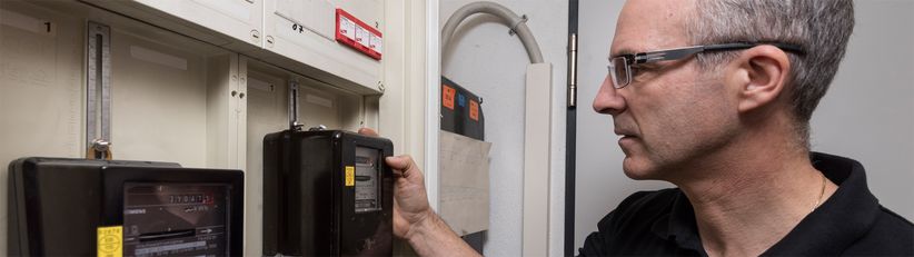 eza!-kommunales-Energiemanagement Auf dem Bild zu sehen ist eza!-Mitarbeiter Rainer Moll aus der Abteilung kommunales Energiemanagement, der gerade dabei ist, eine Heizungsanlage zu optimieren.