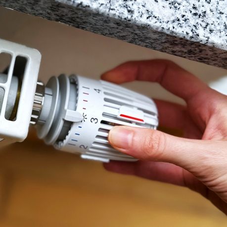 Das Bild zeigt ein Thermostat, das verstellt wird